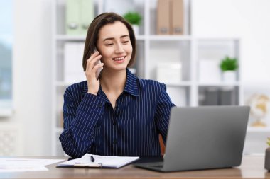 Ofiste telefonda konuşan güzel bir kadın.