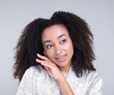 Gri arka planda sağlıklı ciltli güzel Brezilyalı kadın.