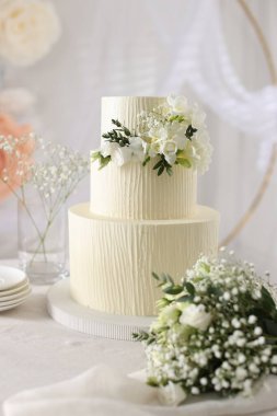 Çiçekli düğün pastası ve kapalı masa desenli lezzetli bir pasta.