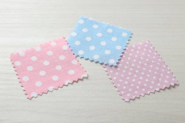 Beyaz ahşap masadaki farklı kumaşlardan örnekler, yakın plan.