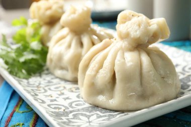 Lezzetli pişmiş khinkali masada servis ediliyor, yakın plan.