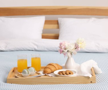 Nefis kahvaltı tepsisi ve yatağın içinde çiçekler. Metin için boşluk