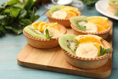 Meyveli tart ve açık mavi ahşap masada nane şekeri, yakın plan. Tatlı nefis.