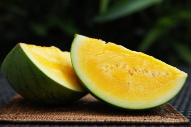 Hasır masada olgun sarı karpuz parçaları, yakın plan.