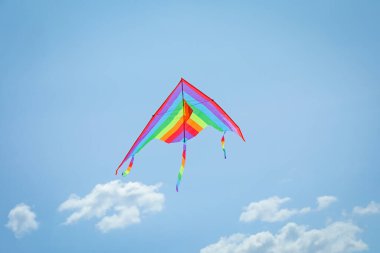 Mavi gökyüzünde uçan renkli uçurtma, alçak açı