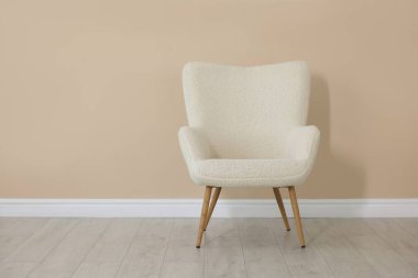 Bej duvarın yanındaki rahat koltuk, metin için boşluk.