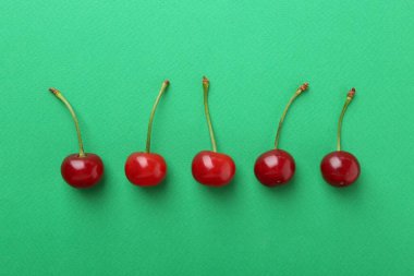 Yeşil zemin üzerinde taze kirazlar, düz uzanmış