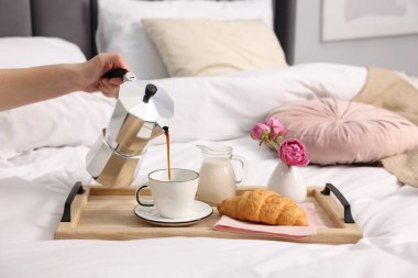 Kadın yatakta nefis bir kahvaltı yapıyor, yakın plan.
