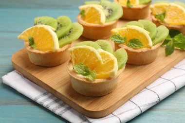 Meyveli tart ve açık mavi ahşap masada nane şekeri, yakın plan. Tatlı nefis.