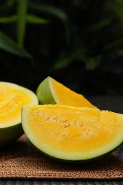 Hasır masada olgun sarı karpuz parçaları, yakın plan. Metin için boşluk