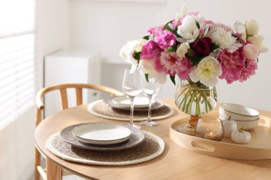 Yemek odasında şakayık demeti olan güzel bir masa, yakın plan.