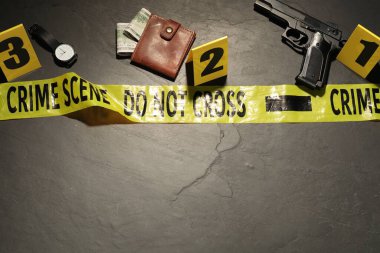 Adli tıp uzmanlığı. Gri arka planda delil, işaretler ve polis bandı olan bir suç mahalli. Metin için boşluk