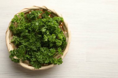 Açık ahşap masada sepetin içinde taze maydanoz, üst manzara. Metin için boşluk