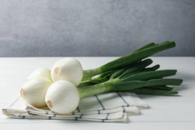 Taze taze yeşil soğan ve beyaz ahşap masada havlu. Metin için boşluk