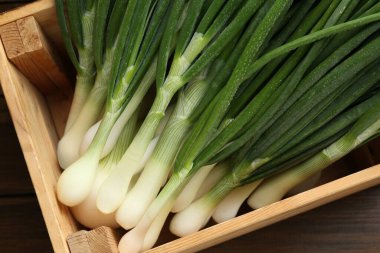 Tahta masadaki sandıkta taze taze taze soğanlar.