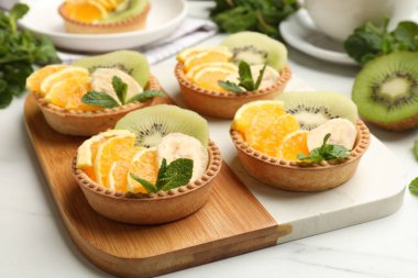 Meyveli turta ve nane şekerli beyaz masa, yakın plan. Tatlı nefis.