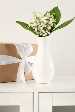 Vadi çiçeklerinin güzel zambakları ve beyaz dolapta hediyeler