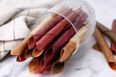 Lezzetli meyveler beyaz mermer masada yuvarlanıyor, yakın plan.