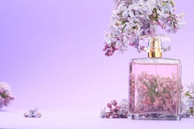 Parfüm şişesi ve mor arkaplanda leylak çiçekleri, yakın plan. Metin için boşluk