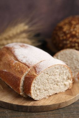 Taze kesilmiş ekmek ve çiviler ahşap masada, yakın plan.