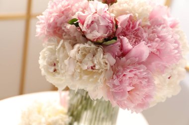 Beyaz masadaki vazodaki güzel şakayıklar, yakın plan.