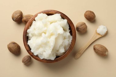 Doğal Shea tereyağı ve fındıklar bej arka planda, düz yatıyordu