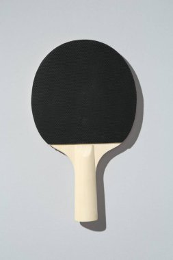Açık arkaplanda bir ping pong raketi, üst görünümde.