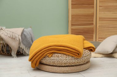 Farklı renkte yün battaniye ve yastıklar.