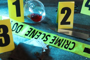 Adli tıp uzmanı. Sarı olay yeri bandı, işaretler, para dolu cüzdan, bıçak ve şarap kadehi gri masada, yakın plan.