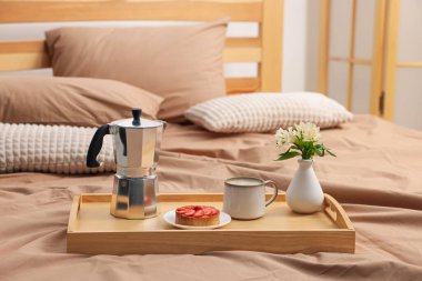 Nefis kahvaltı tepsisi ve yatağın içinde çiçekler. Metin için boşluk