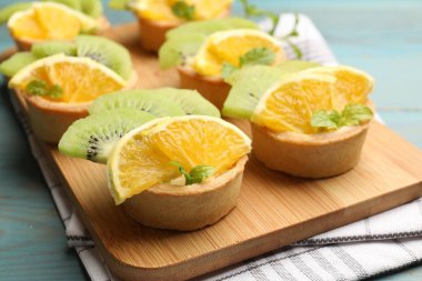 Meyveli tart ve açık mavi ahşap masada nane şekeri, yakın plan. Tatlı nefis.