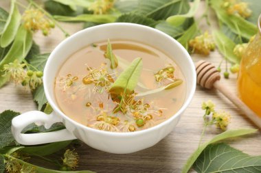 Taze ıhlamur çayı, bal ve çiçekler ahşap masada, yakın plan.