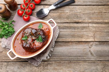 Geleneksel ossobuco yemeği. Biftek, ahşap masada servis edilir.