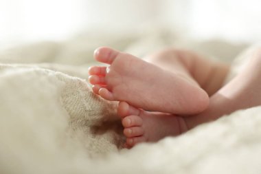 Sevimli yeni doğmuş bebek, yatakta uzanıyor, yakın plan.