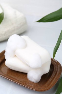 Beyaz masadaki köpüklü sabun çubukları, yakın plan.