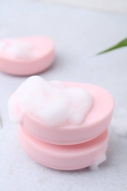 Beyaz masadaki köpüklü sabun çubukları, yakın plan. Metin için boşluk