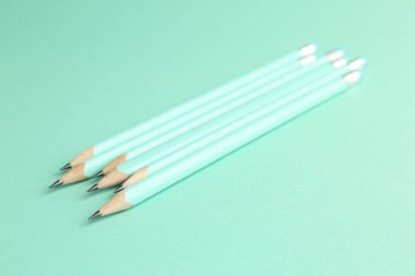 Turkuaz arka planda birçok grafit kalem, yakın plan