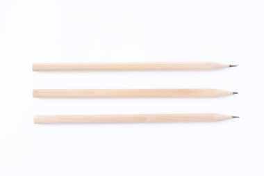 Beyaz zemin üzerinde üç grafit kalem, düz yatıyordu.