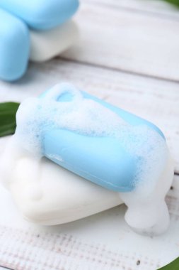 Köpüklü sabun çubukları beyaz ahşap masa, yakın plan.