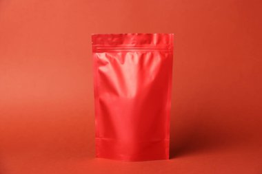 Kırmızı arka planda fermuarlı bir stand-up kesesi. Tasarım için model