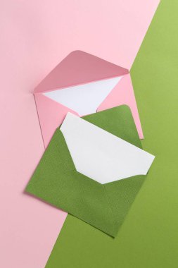 Renk arkaplanı üzerindeki boş davetiye kartları ve zarflar, düz konum