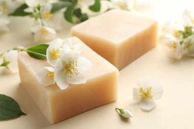 Bej arka planda sabun ve yasemin çiçekleri, yakın plan.