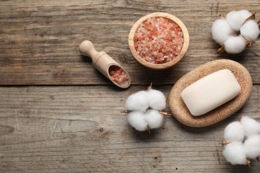 Sabun çubuğu, deniz tuzu ve pamuk çiçekleri ahşap masada, düz yerde. Metin için boşluk
