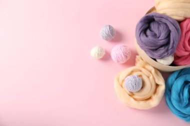 Pembe arka planda yün ve örgü ipliği, düz yatış. Metin için boşluk