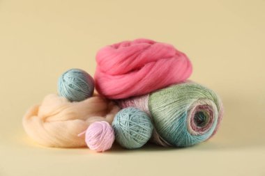 Bej arka planda yün ve örgü ipliği hissetmek, yakın plan