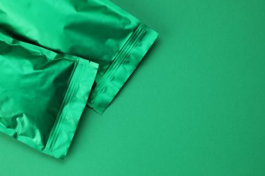 Yeşil arka planda fermuarlı stand-up çantaları, üst manzara. Tasarım için model