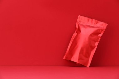 Kırmızı arka planda fermuarlı stand-up kesesi. Tasarım için model