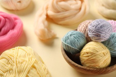 Bej arka planda yün ve örgü ipliği hissetmek, yakın plan