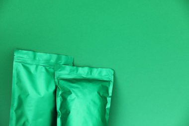 Yeşil arka planda fermuarlı stand-up çantaları, üst manzara. Tasarım için model