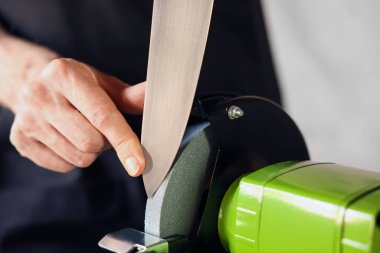 Bıçak keskinleştiren adam içeride, yakın plan.